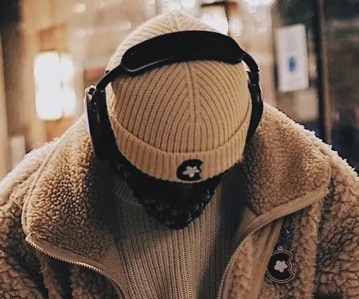 johnKeysCloud looking down in a knit beanie, headphones, and a sherpa fleece jacket